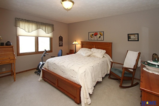 bedroom with baseboards and light carpet
