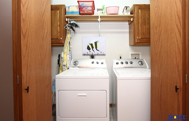 washroom with washer and clothes dryer and cabinet space