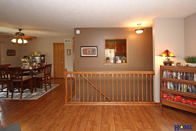 dining area featuring hardwood / wood-style floors, a ceiling fan, and visible vents