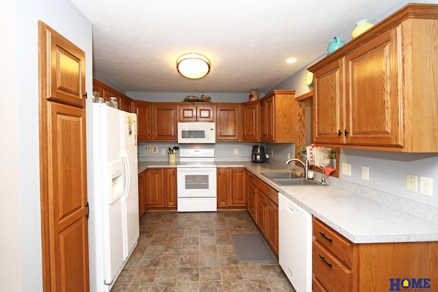 kitchen featuring brown cabinetry, white appliances, light countertops, and a sink