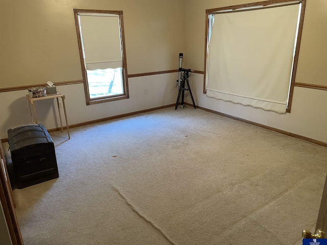carpeted spare room featuring baseboards