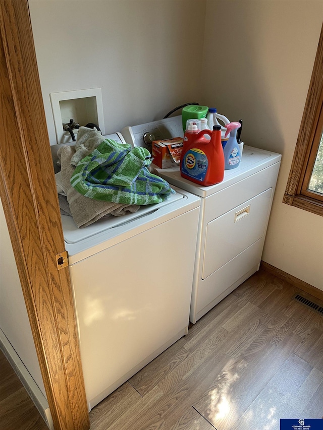 laundry room with visible vents, light wood-style floors, laundry area, and independent washer and dryer