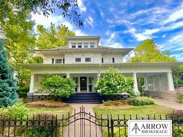 view of front of home featuring a porch, a fenced front yard, a front lawn, and a gate