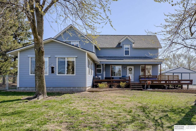 view of front of house with a front yard, a shingled roof, covered porch, fence, and a gate