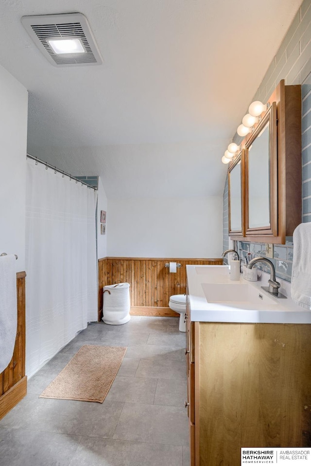 full bathroom featuring vanity, visible vents, a wainscoted wall, toilet, and a shower with shower curtain