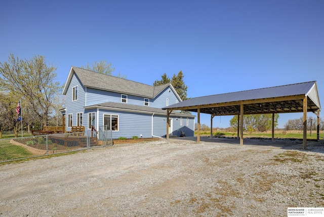 exterior space featuring a carport, fence, and driveway