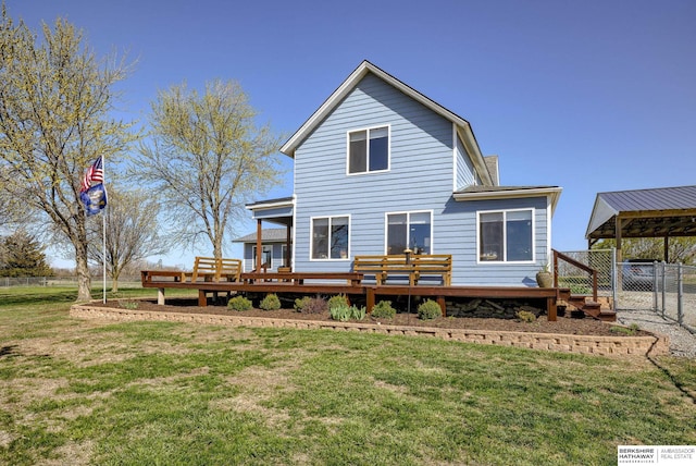 back of property featuring a yard, fence, a deck, and a gate