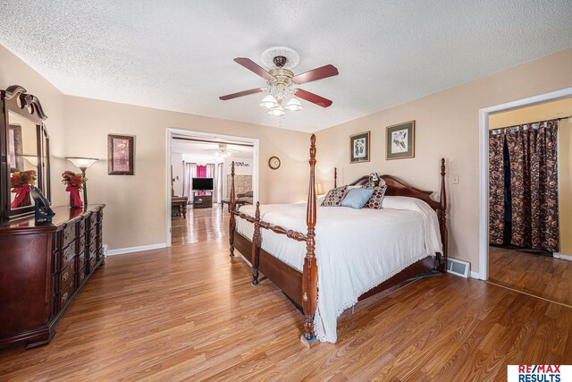 2860 335th St, Logan, IA 51546 - bedroom with a textured ceiling, wood finished floors, baseboards, and visible vents