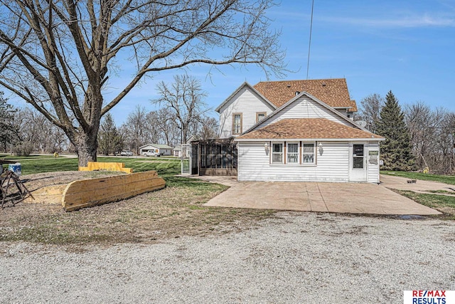 2860 335th St, Logan, IA 51546 - view of side of home featuring a patio area, a sunroom, and roof with shingles