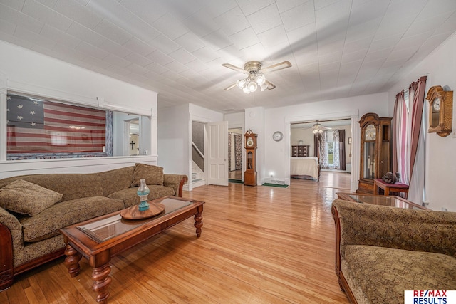 2860 335th St, Logan, IA 51546 - living room featuring stairway, light wood-style floors, baseboards, and ceiling fan