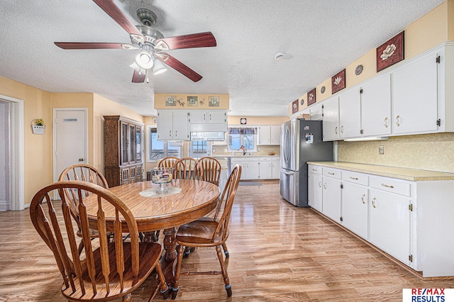 2860 335th St, Logan, IA 51546 - dining room with light wood-style floors, a textured ceiling, and ceiling fan