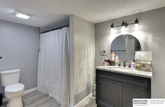 161 S Linden St, Wahoo, NE 68066 - bathroom featuring a textured ceiling, wood finished floors, toilet, vanity, and baseboards