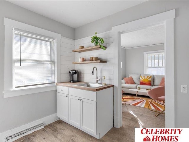 3361 N 59th St, Omaha, NE 68104 - kitchen featuring a sink, visible vents, light wood-type flooring, and white cabinetry
