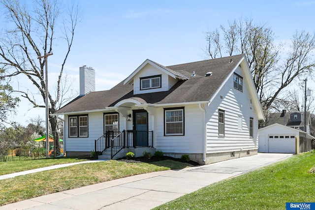 bungalow featuring an outbuilding, a garage, a front lawn, a chimney, and driveway