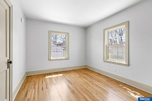 spare room with light wood finished floors and baseboards