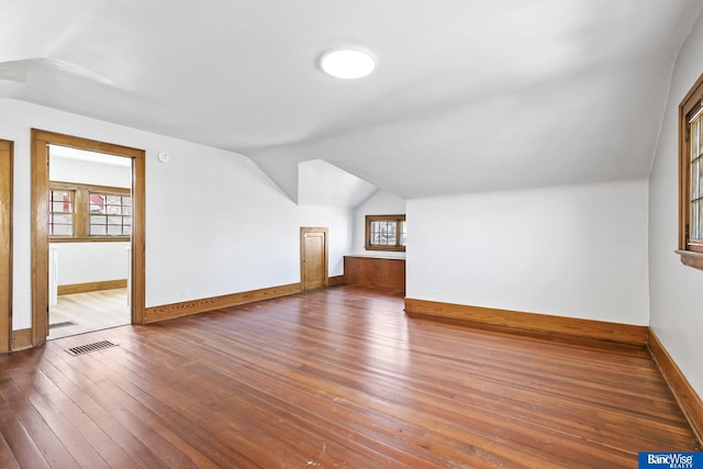 bonus room with visible vents, baseboards, hardwood / wood-style flooring, and lofted ceiling