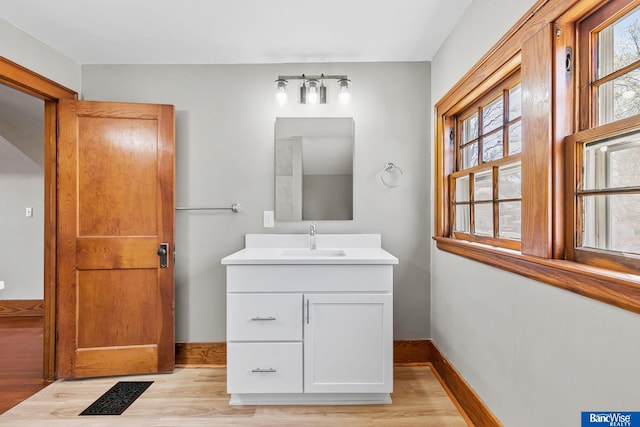 bathroom featuring a healthy amount of sunlight, wood finished floors, and vanity