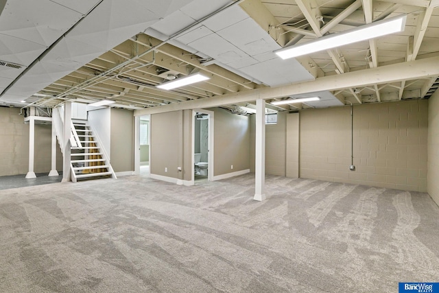 below grade area with stairway, visible vents, and carpet floors