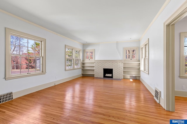 unfurnished living room with baseboards, a fireplace, light wood-style flooring, crown molding, and visible vents