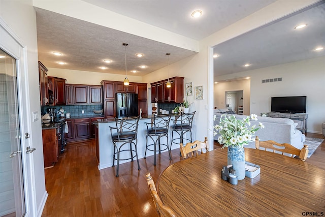 dining room featuring visible vents, recessed lighting, and dark wood-type flooring