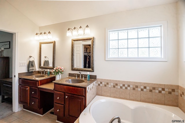 full bath with a bath, a sink, tile patterned flooring, and double vanity