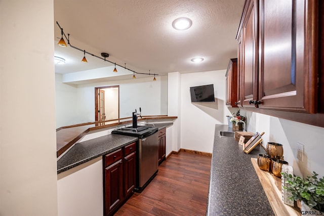 kitchen featuring a peninsula, a sink, dark wood finished floors, dark brown cabinets, and baseboards