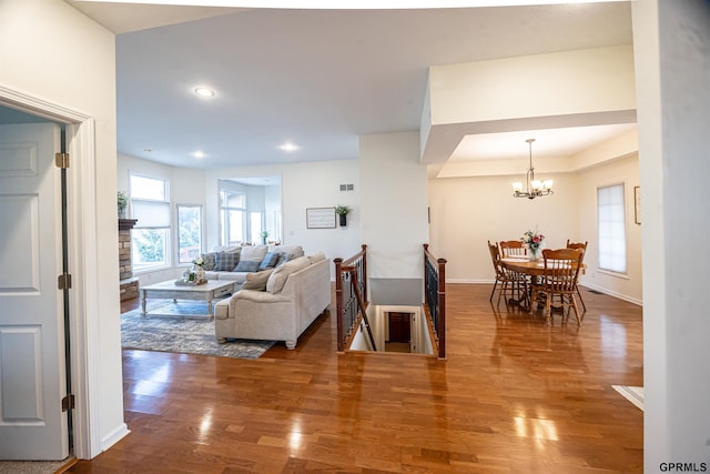 living room featuring baseboards, a chandelier, wood finished floors, and recessed lighting