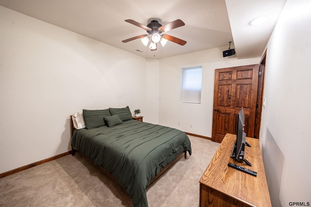 bedroom featuring baseboards, a ceiling fan, and light colored carpet