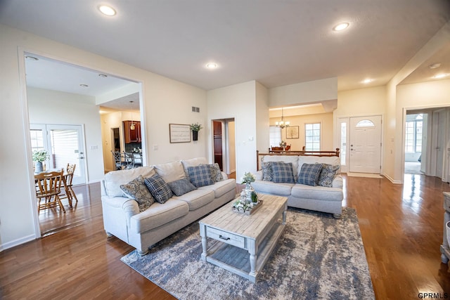 living area with visible vents, recessed lighting, a notable chandelier, and dark wood-style flooring