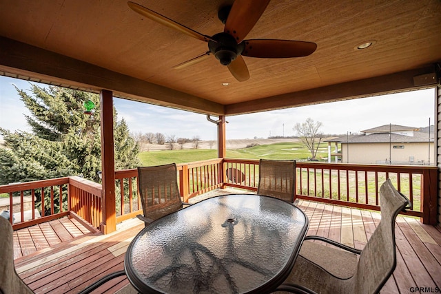 wooden terrace with a lawn, a ceiling fan, outdoor dining area, and view of golf course