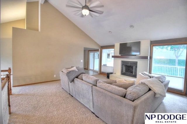 living area with a glass covered fireplace, a ceiling fan, high vaulted ceiling, and carpet floors