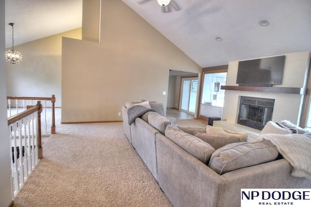 living room with a chandelier, high vaulted ceiling, a glass covered fireplace, light carpet, and baseboards
