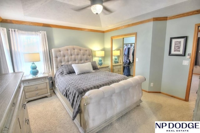 bedroom with light colored carpet, a closet, ornamental molding, ceiling fan, and baseboards