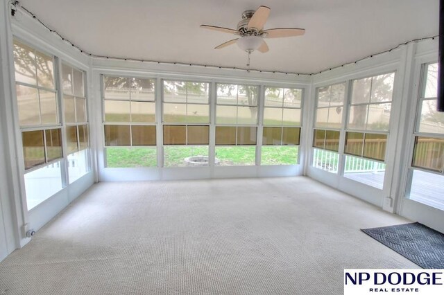 unfurnished sunroom with a ceiling fan