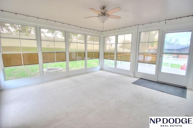 unfurnished sunroom with a wealth of natural light and ceiling fan