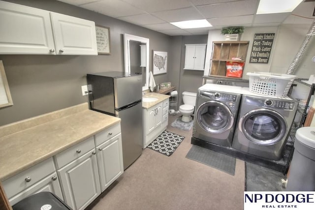 clothes washing area with separate washer and dryer and a sink