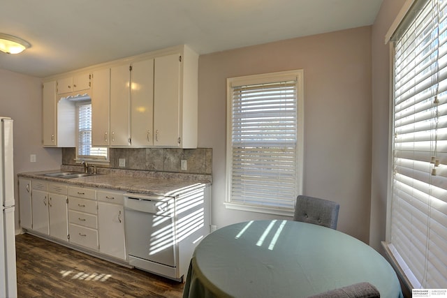 kitchen featuring a sink, dark wood-style flooring, light countertops, white appliances, and backsplash