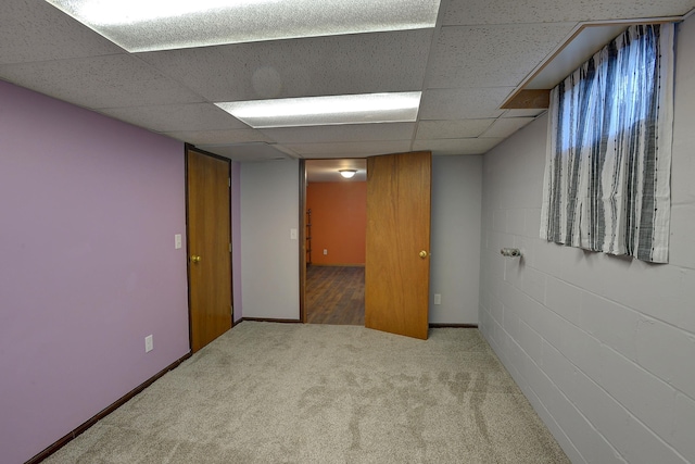 carpeted empty room featuring a drop ceiling