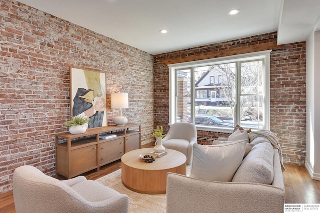 sitting room featuring brick wall, recessed lighting, and light wood-type flooring