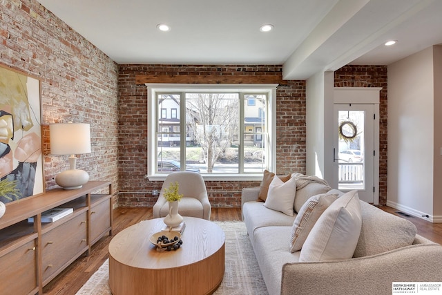 living area with brick wall, visible vents, and plenty of natural light
