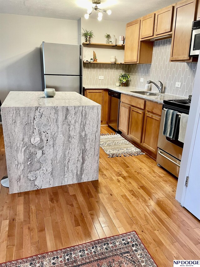 105 N 31st Ave Unit 607, Omaha, NE 68131 - kitchen with tasteful backsplash, open shelves, appliances with stainless steel finishes, a sink, and light wood finished floors