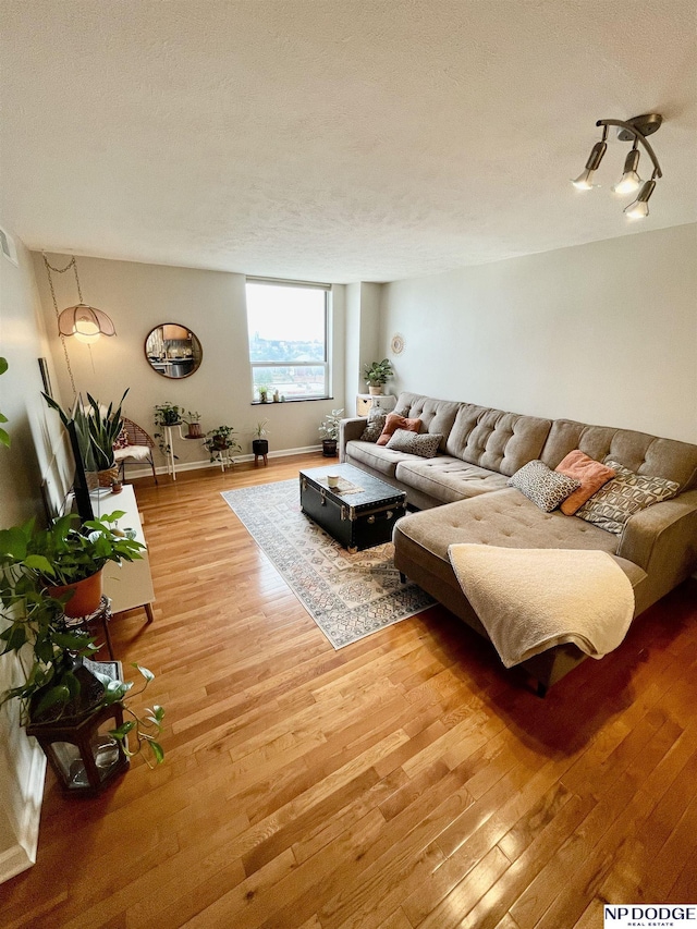 105 N 31st Ave Unit 607, Omaha, NE 68131 - living room featuring baseboards, light wood-style floors, and a textured ceiling