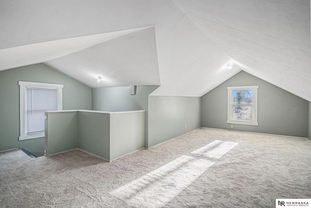 additional living space with carpet flooring and lofted ceiling