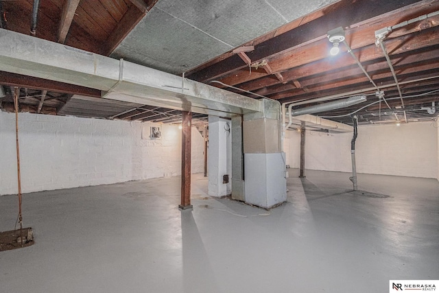 unfinished basement featuring heating unit