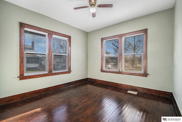 unfurnished room with visible vents, baseboards, a ceiling fan, and dark wood finished floors