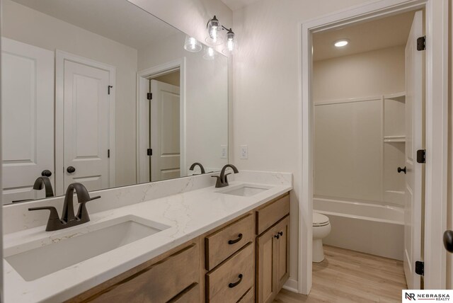 11014 N 161st St, Bennington, NE 68007 - bathroom with toilet, wood finished floors, double vanity, and a sink