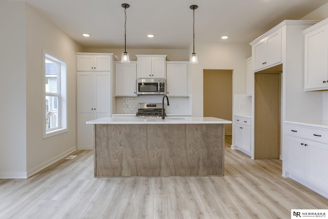 11014 N 161st St, Bennington, NE 68007 - kitchen with a sink, appliances with stainless steel finishes, light wood-style floors, white cabinetry, and backsplash