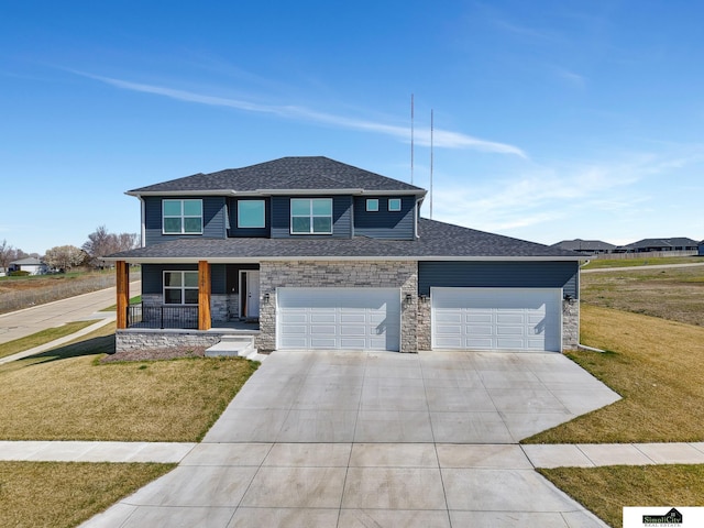 view of front of property featuring driveway, stone siding, a front lawn, a shingled roof, and covered porch
