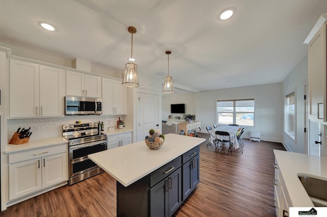 kitchen featuring dark wood finished floors, white cabinetry, light countertops, and appliances with stainless steel finishes