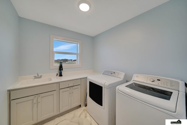 laundry area with marble finish floor, a sink, washing machine and clothes dryer, and cabinet space